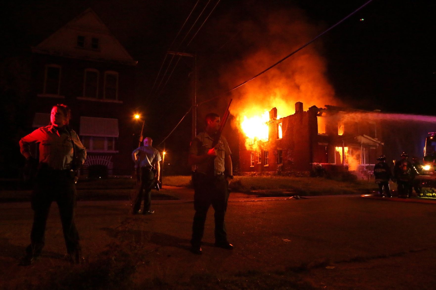 Officers guard firefighters at burning house on Bayard